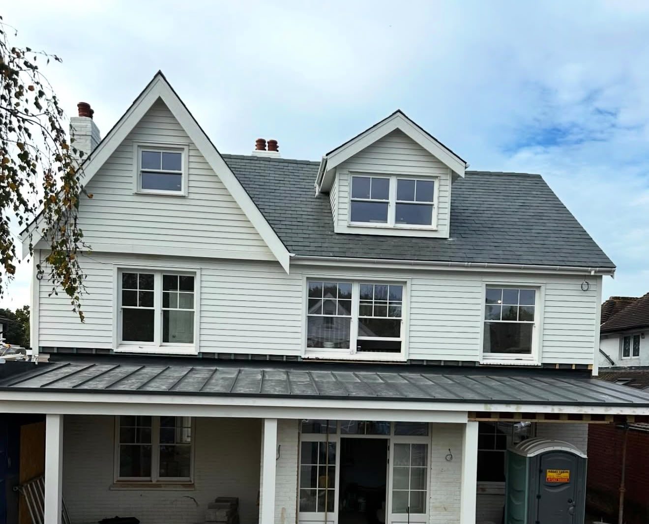 New build extension with a standing seam flat roof over the veranda